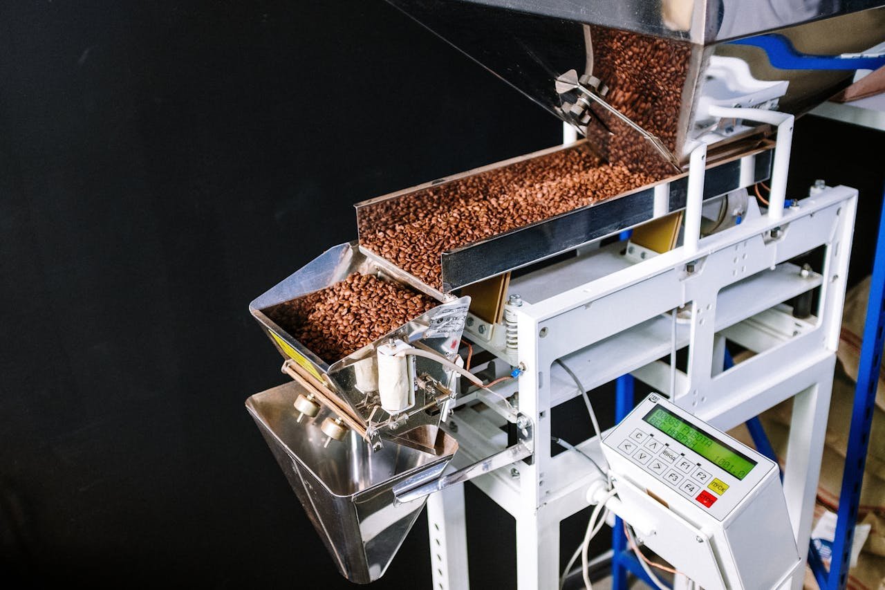 Automated machine sorting roasted coffee beans with control panel for efficient production.